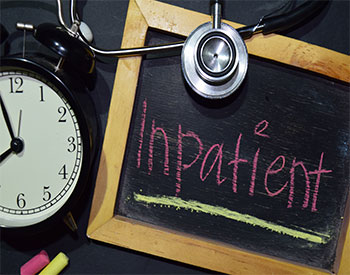 The words Inpatient handwriting on chalkboard on top view.
