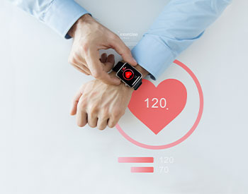 close up of hands with heart icon on smart watch